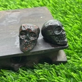 Carved skull figurines in dark red speckled jasper and polished black stone finish - Plum Blossom Jade