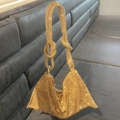 Close-up of golden rhinestone mesh handbag featuring a decorative knot handle detail - Standard Size / Gold