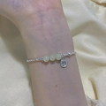 Silver bead bracelet with green stones and Fu pendant on wrist against silk fabric - Fu Word Green Bead Fine Chain (SL1239)