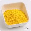Macro shot of 3mm bright yellow round glass seed beads piled in a white square bowl - KK08 Golden Yellow