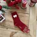 Thick red Christmas socks with apple pattern and lucky text in a festive setting - Red with White Apple