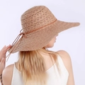 Close-up detail of a wide-brimmed straw sun hat with breathable lace texture and bow tie - Khaki