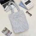 Flat lay of blue checkered canvas tote bag with Sozakka embroidery and ruffled handle - White Checkered