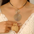 Close-up of golden geometric disc pendant necklace and matching earrings on a model - Necklace and Earring Set / Gold