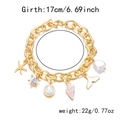 Detailed view of a gold ocean charm bracelet with starfish, turtle, and shell charms - Bracelet / Gold with White Pearl