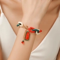 Kerstarmband met rood-groen-witte schakels en Merry Christmas-label op pols - Merry Christmas Label