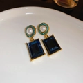 Detail of blue crystal and pearl flower earring on a white ceramic display plate - Dark Blue Square Cut Gem Pearl Studs (7#)