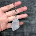 Handheld view of a raw white crystal keychain with iridescent rainbow luster and silver ring - Electroplated Aura Quartz
