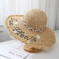 Dettaglio cappello da sole in rafia intrecciata a mano con ricamo e pizzo floreale - Fiori bianchi e rosa chiaro