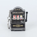 Dettaglio ravvicinato di un portachiavi a slot machine in metallo con leva e rulli mobili - Nero canna di fucile