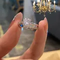 Close-up of a silver six-prong wedding ring with a large central crystal and side stones - TJZ210-Opening Six-Prong Pave