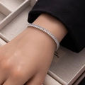 Close-up of silver baguette-cut tennis bracelet worn with elegant black blazer - Silver Small Rectangle