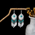 Detail of bohemian silver earrings with turquoise beads and feather pendants on wood - E3825/Blue