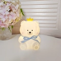 Cute bear night light with yellow crown and blue plaid bow, emitting warm glow - Nini Bear White - Blue Ribbon