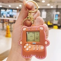 Dettaglio di un mini portachiavi console gioco a forma di orso bruno con schermo LCD - Cachi