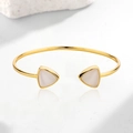 Gold open cuff bracelet featuring two white triangular cat eye stones on marble - Gold Color Bracelet