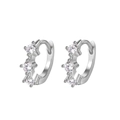 Close-up of silver hoop earrings with three inlaid sparkling zirconias on white background - Minimalist Three-Stone Hoop-Silver