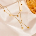 Detail of gold star and moon tassel anklet set on elegant champagne silk fabric - Star Moon Tassel Necklace (D502) / Gold
