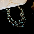 Macro detail of multi-layered gold necklace with sparkling teal zircon stones - Blue Zirconia Multi-layer Necklace
