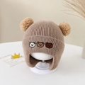 Close-up of baby winter knit hat featuring three embroidered bears and dual pom-poms - 6 Months - 2 Years / Brown