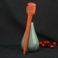 Macro detail of hand-carved sandalwood hair pin featuring a totem face in a ceramic vase - Human Face Totem (F2023786)