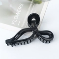 Elegant black glossy hair claw clip with a sleek knotted design on marble surface - Bright Black
