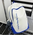 Detalle de mochila de lona blanca y azul con colgante de rana en carrito de metal - Mochila azul real sin colgante