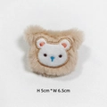 Detail of plush beige bear patch with blue nose and embroidery, 5cm by 6.5cm size - Khaki Bear