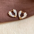 Primo piano dei piccoli orecchini a cuore in oro 18 carati con filo bianco intrecciato - Bianco