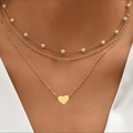 Three-layer gold necklace with pearls and a polished heart pendant on a female model - Gold Triple Layer Heart Pearl