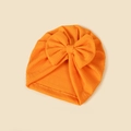 Detailed view of the bright orange waffle texture fabric and large bow on the baby turban hat - 18.5x17cm / Orange Red