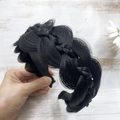Hand holding a black braided fishtail synthetic fiber headband for hair volume - Natural Black