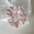 Nahaufnahme eines hellrosa Scrunchie mit plissiertem Chiffon auf weißem Hintergrund - Wasserrosa