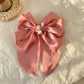 Pink satin butterfly hair claw clip with pearl center on a textured background - Deep Pink