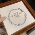 Close-up detail of elegant silver 18K gold plated bracelet with pink zircon stones. - Silver