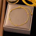 Close-up of a gold-tone snake chain bracelet with beads and a small bell pendant charm - JLB79 Round Bead Snake Chain
