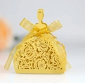 Detail of gold laser-cut bridal dress gift box with intricate rose patterns and yellow ribbon - Gold