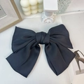 Detail einer großen schwarzen Satinschleife Haarspange mit Hochglanz-Finish auf Tisch - Einfacher Satin / Schwarz