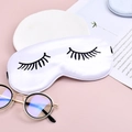White satin silk sleep mask with black eyelash print on pink and white surface - White