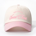 Gros plan sur la broderie rose 'HERE FOR THE' sur une casquette en coton crème et rose - Réglable / Blanc Crème & Rose