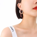 Polished silver twisted hoop earring in a minimalist design worn by a female model - Small / Steel