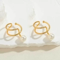 Minimalist golden spiral ear cuff earrings with white pearls on a natural stone base - Gold Spiral Pearl Style