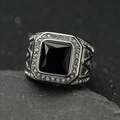 Vintage stainless steel ring with square black gemstone and diamonds on a rock background - Steel + Black Stone