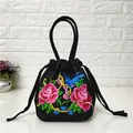 Detail of floral embroidery with blue bird and pink roses on black canvas bucket bag - Pink Rose