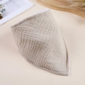 Detail view of a beige double-layer gauze baby bib with soft wrinkled fabric texture - Khaki