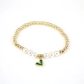 Close-up of gold beads and white pearls bracelet with a green heart crystal pendant - Green