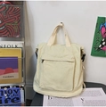 Minimalist creamy beige canvas backpack with large front zipper pocket for daily commute - Off White