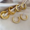 Three pairs of golden polished and textured round stud earrings on champagne satin - Striped / Smooth / Horizontal Grain / 3# Gold (3-Pair Set)
