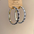 Close-up of gold metal hoop earrings featuring black and white houndstooth fabric wrapping - Black & White Houndstooth (Silver Needle)