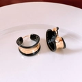 Dettaglio di orecchini a cerchio placcati oro 18k con smalto nero a goccia d'olio - Nero Dorato